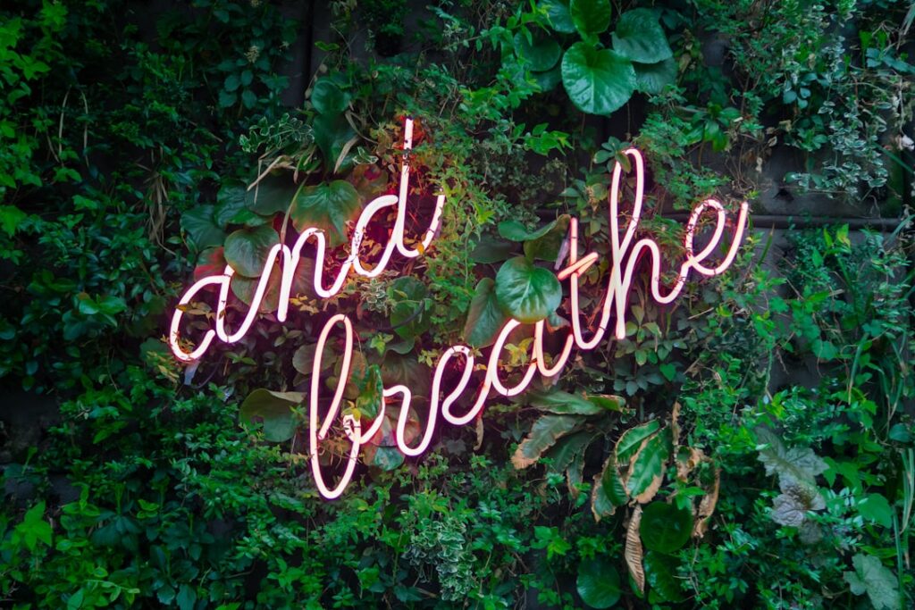 Neon sign that says "and breathe"