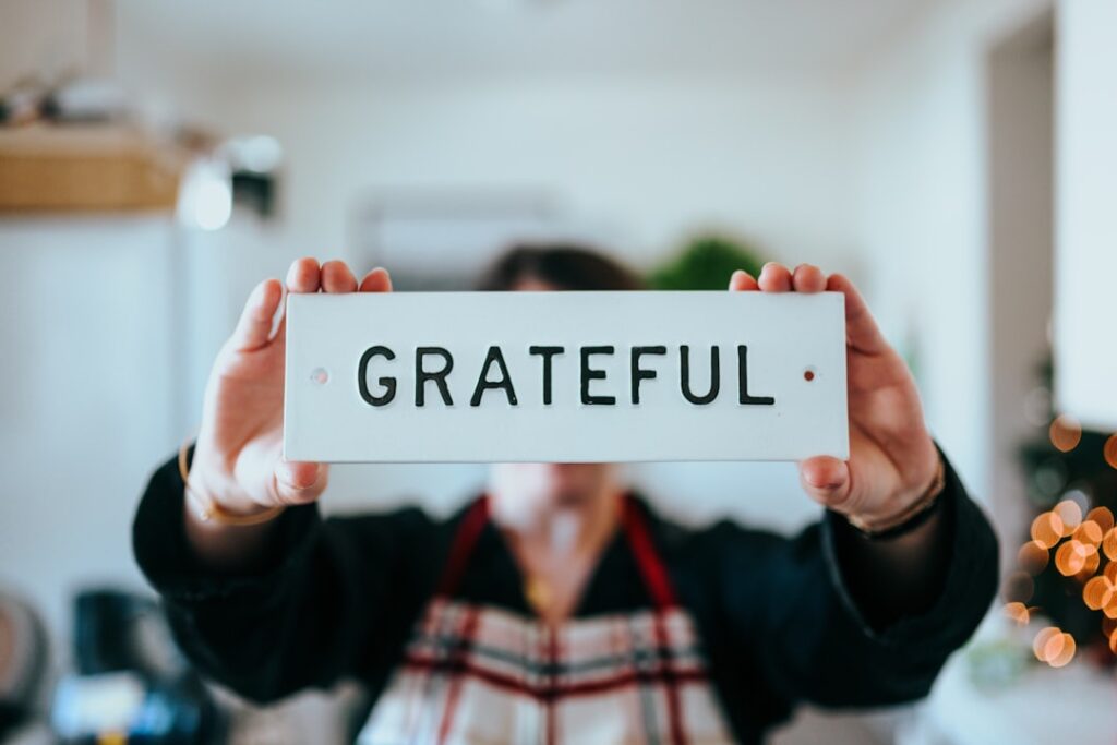 Personal holding sign that says "grateful"